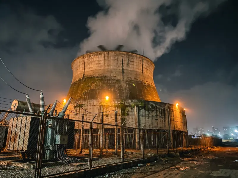 Karachi power-plant hyperbolic cooling tower lit at night — anchor case study for AD-401 biocide programme